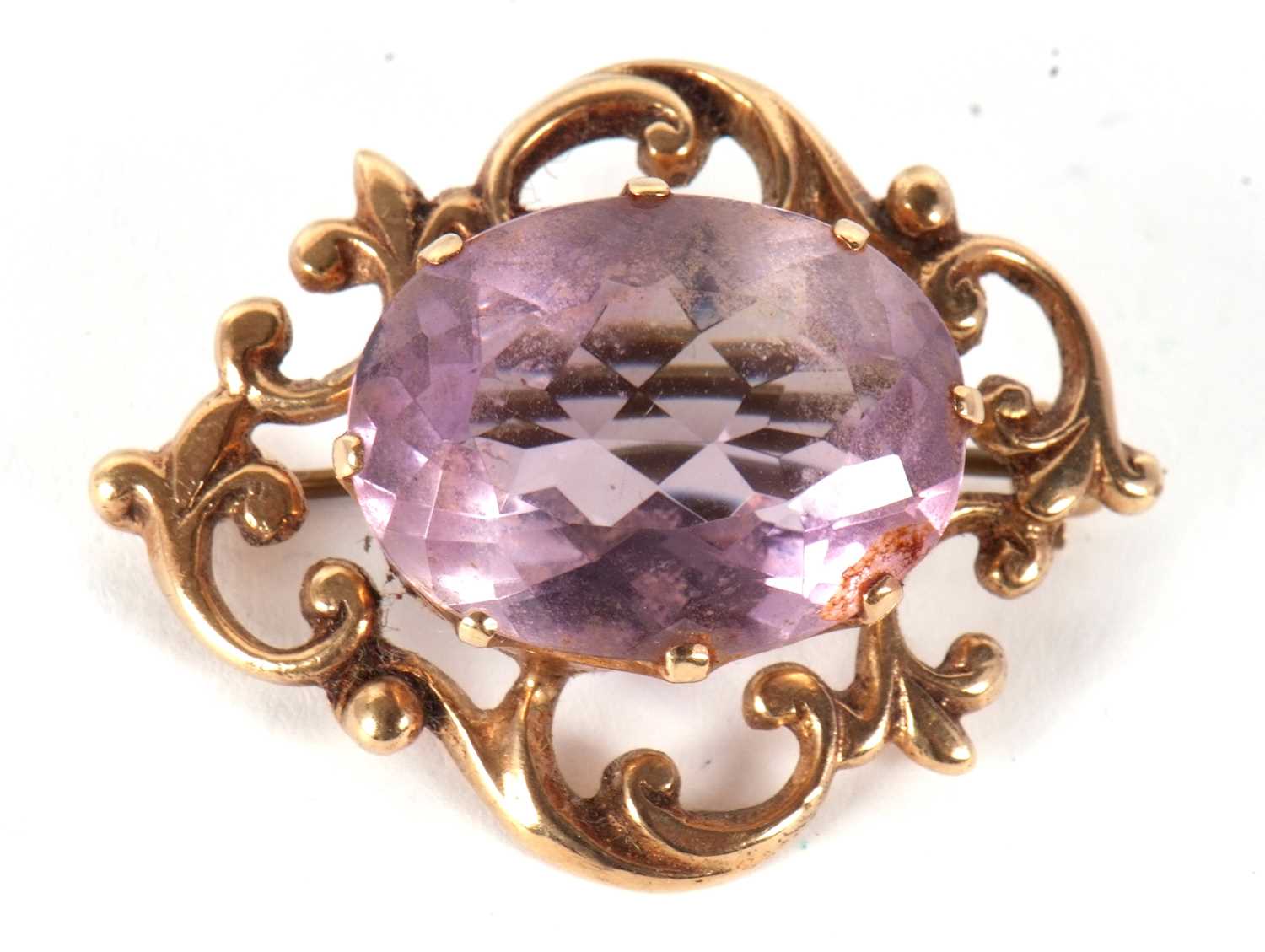 A 9ct amethyst brooch, the oval claw mounted amethyst, surrounded by a scrolled frame yellow gold, - Image 3 of 3