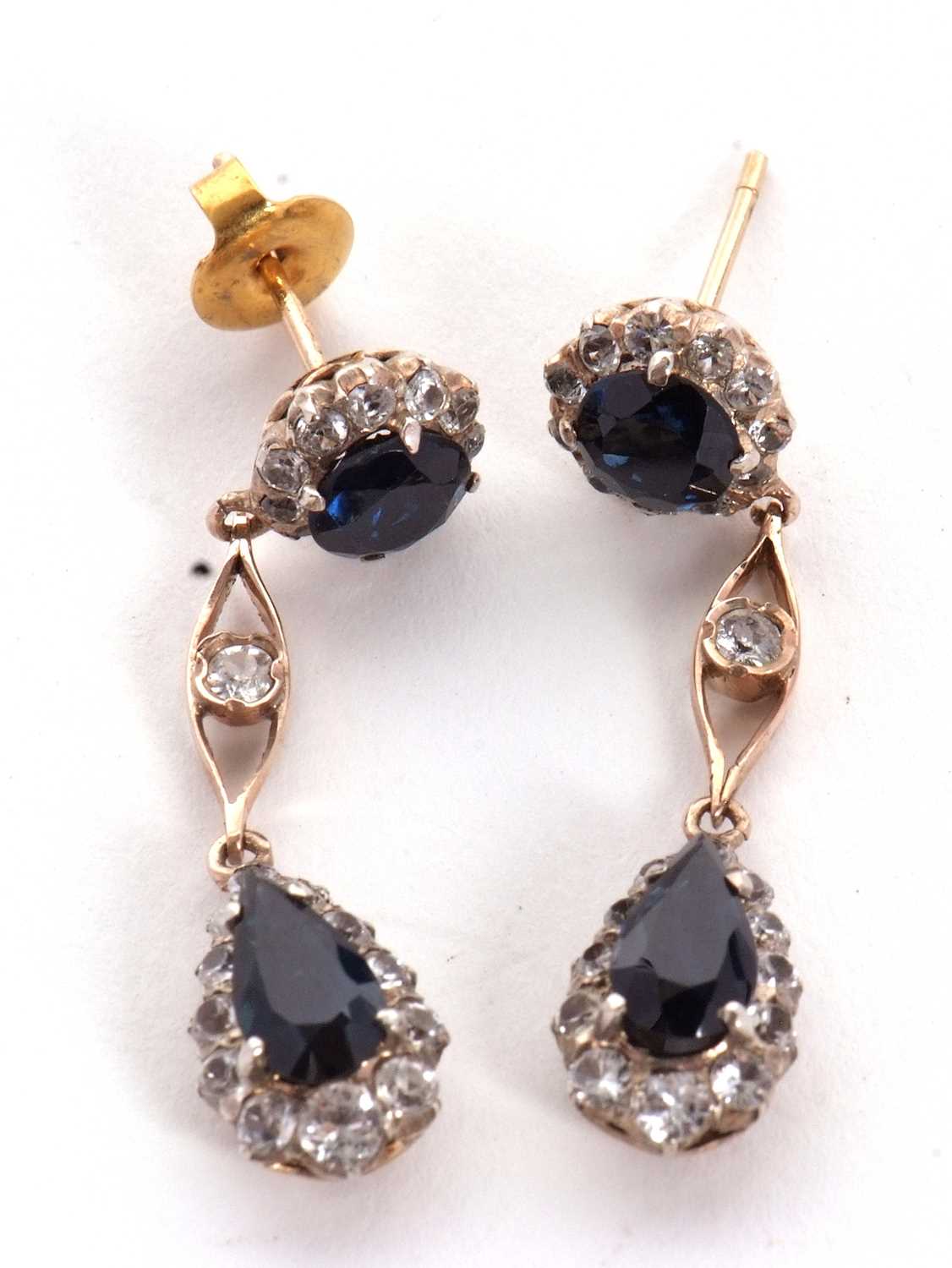 A pair of sapphire and white stone earrings, the round blue sapphire surrounded by small white - Image 2 of 5