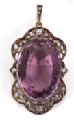 An amethyst and diamond pendant, the oval claw mounted mixed cut amethyst, surrounded by an outer