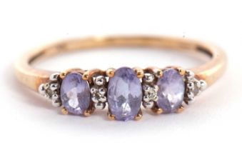 A 9ct tanzanite and white stone ring, the three slightly graduated oval tanzanites interspaced