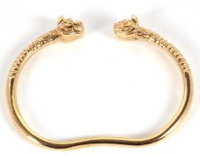 A French reproduction Iranian Achemendide bangle, with lion head terminals and ridged neck and plain