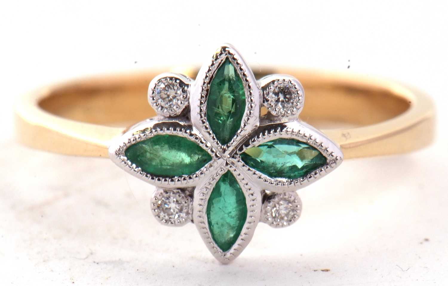 An 18ct emerald and diamond ring, the four marquise shape emeralds interspaced with small round