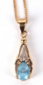 A 9ct topaz pendant and chain, the pear shape topaz set with three small round diamonds above, all