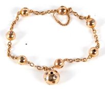 A seed pearl charm bracelet, the yellow metal chain with spheres set with seed pearls, each