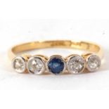 A sapphire and diamond ring, set to centre with a round sapphire and two mixed cut diamonds to