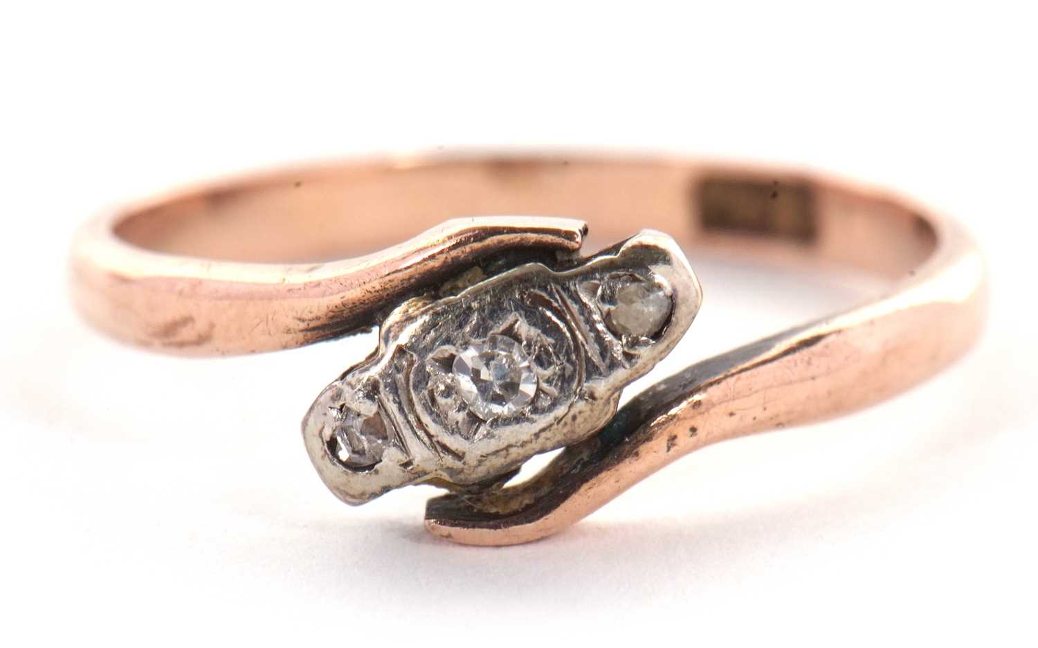 A 9ct diamond ring, the three small round diamonds, illusion mounted in a crossover band of rose - Image 2 of 7