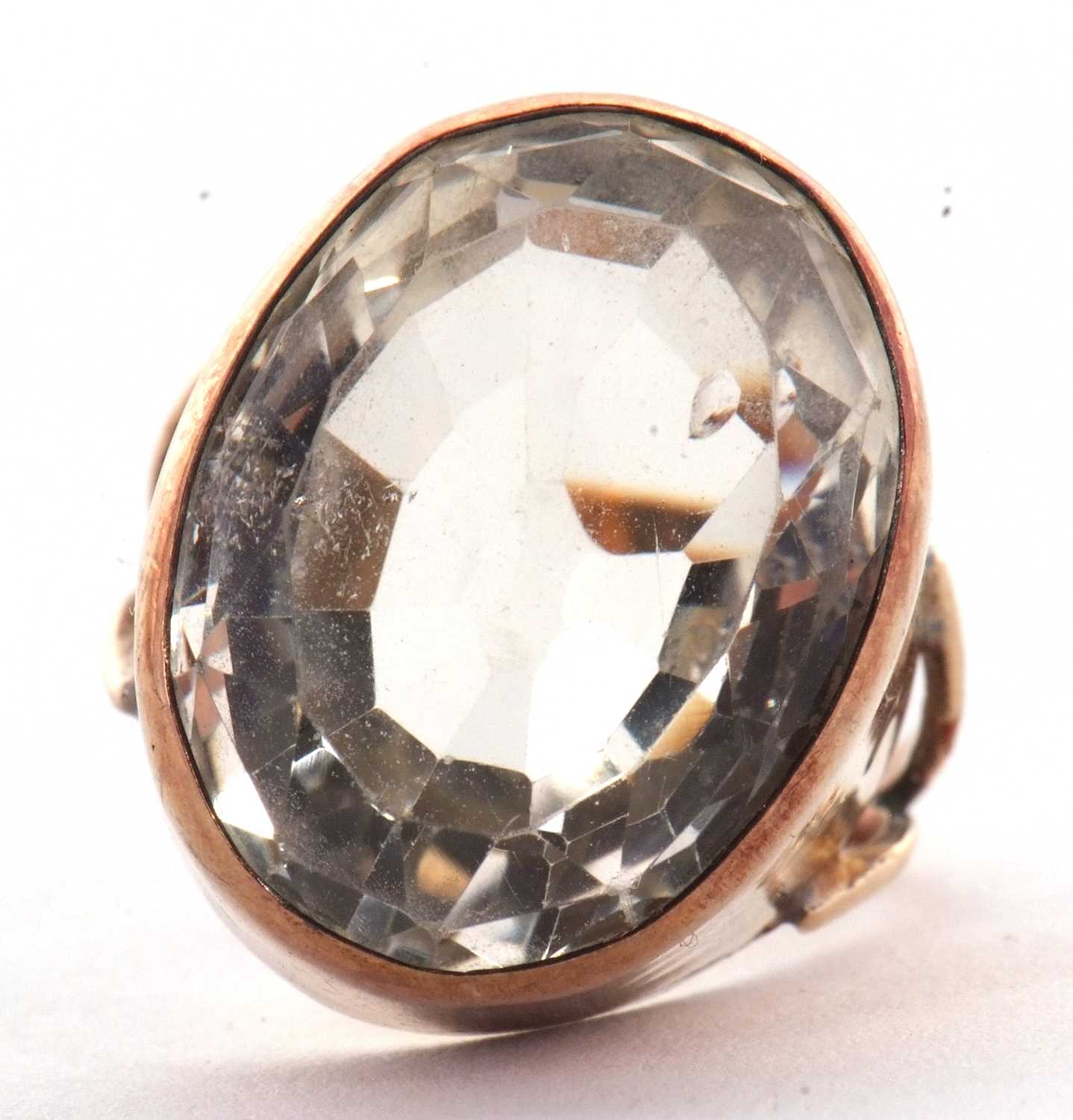 A citrine ring, the oval mixed cut citrine in a deep collet mount, with split shoulders and plain