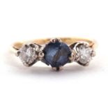 A sapphire and diamond ring, the round mixed cut sapphire set to either side with a round