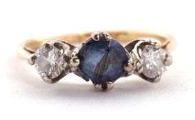 A sapphire and diamond ring, the round mixed cut sapphire set to either side with a round