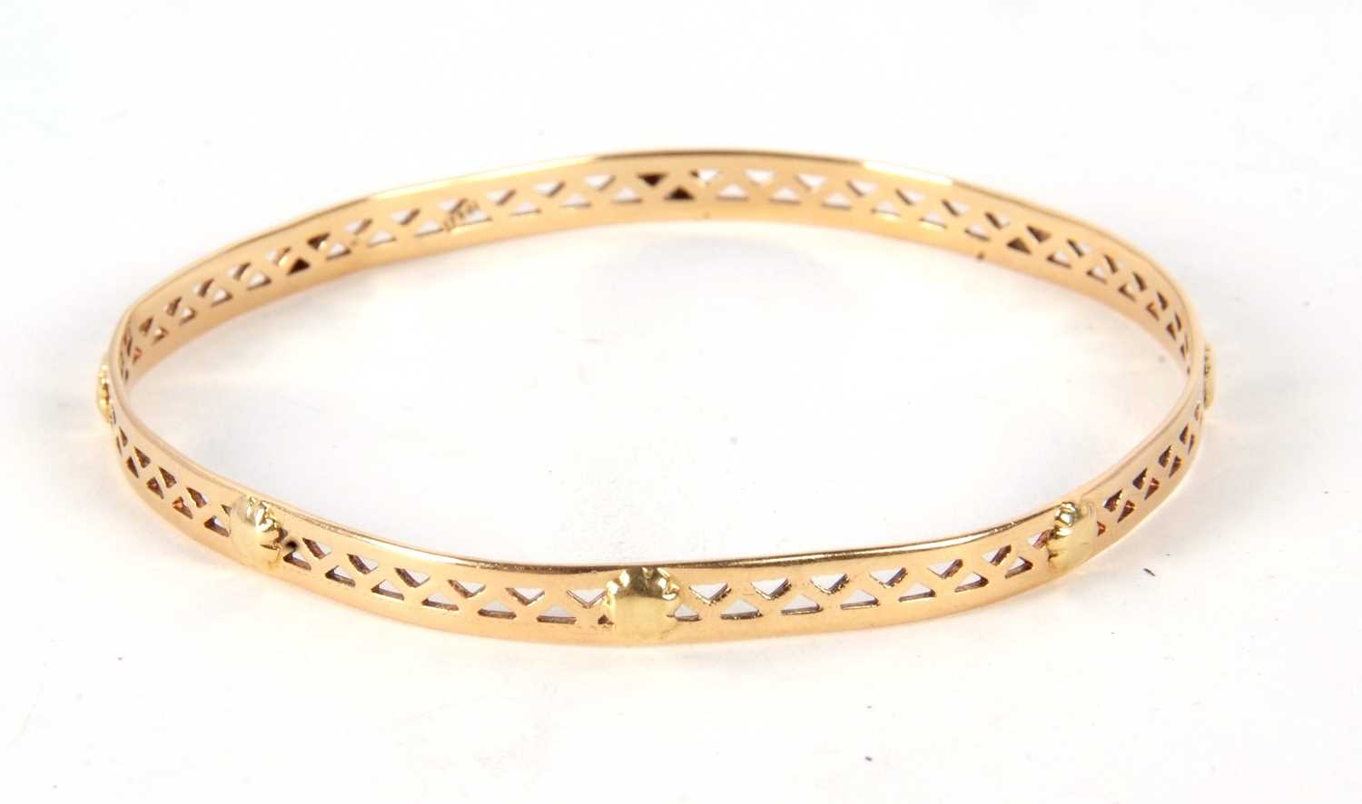 A bangle stamped 750, the 5mm wide pierced bangle with raised bead design, stamped 750, inner