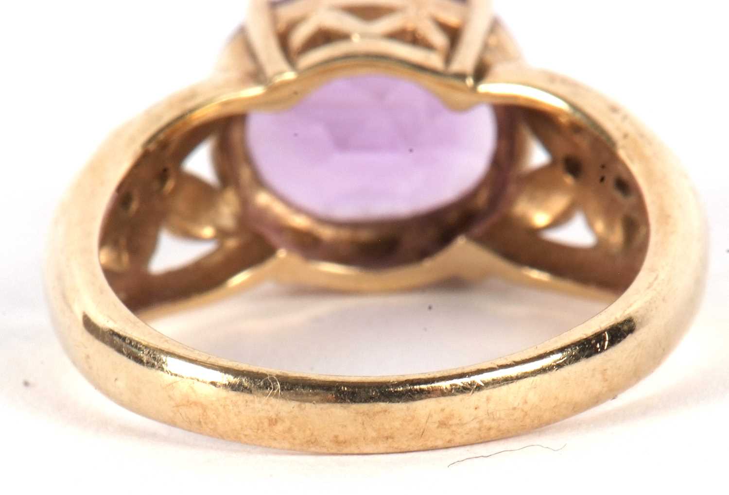 A 9ct amethyst ring, the oval amethyst in a four claw mount, with tapered pierced shoulders set with - Image 3 of 7