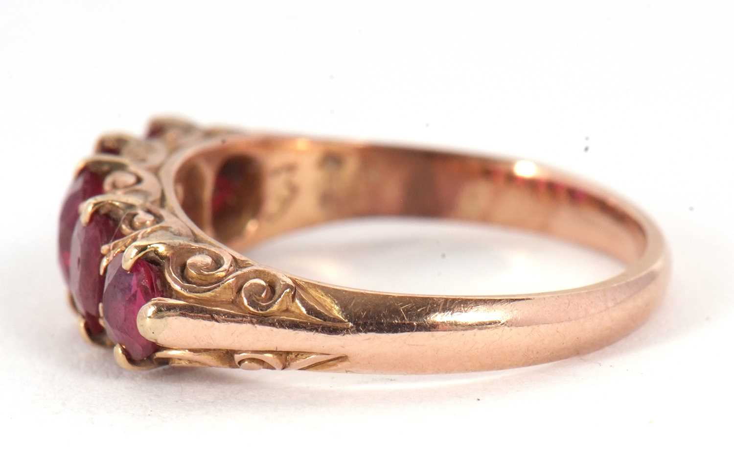 A five stone ruby ring, the five graduated rubies all claw mounted with a scrolled gallery and - Image 5 of 7