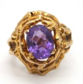A mid 20th century 9ct amethyst ring, the oval amethyst in a four claw mount, set within a modernist