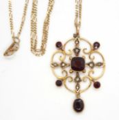 A 9ct Edwardian garnet and seed pearl pendant and a 9KT chain, the pendant set wtih a central
