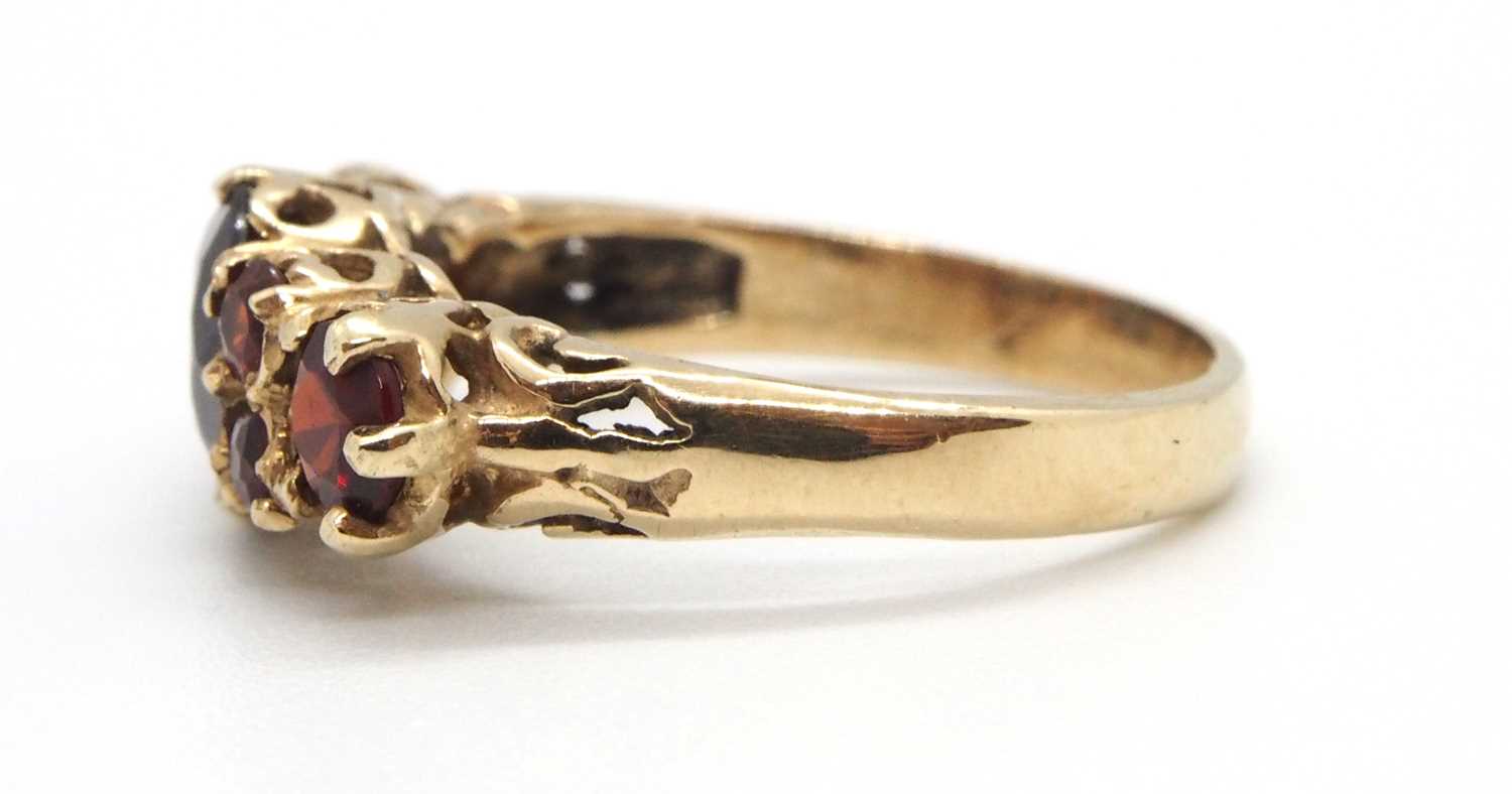 A 9ct garnet ring, the three principal graduated round garnets interspaced with small round garnets, - Image 3 of 7