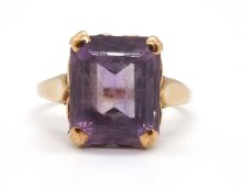An amethyst ring, the emerald cut amethyst, in a four claw mount with heart shape detail to