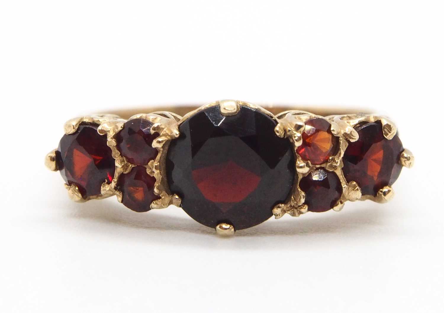 A 9ct garnet ring, the three principal graduated round garnets interspaced with small round garnets, - Image 2 of 7