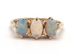 A 9ct opal ring, the three oval claw mounted opal cabochons, with plain band hallmarked Sheffield