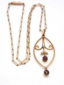 An Edwardian garnet and seed pearl pendant and chain, the marquise shape frame with supsended garnet