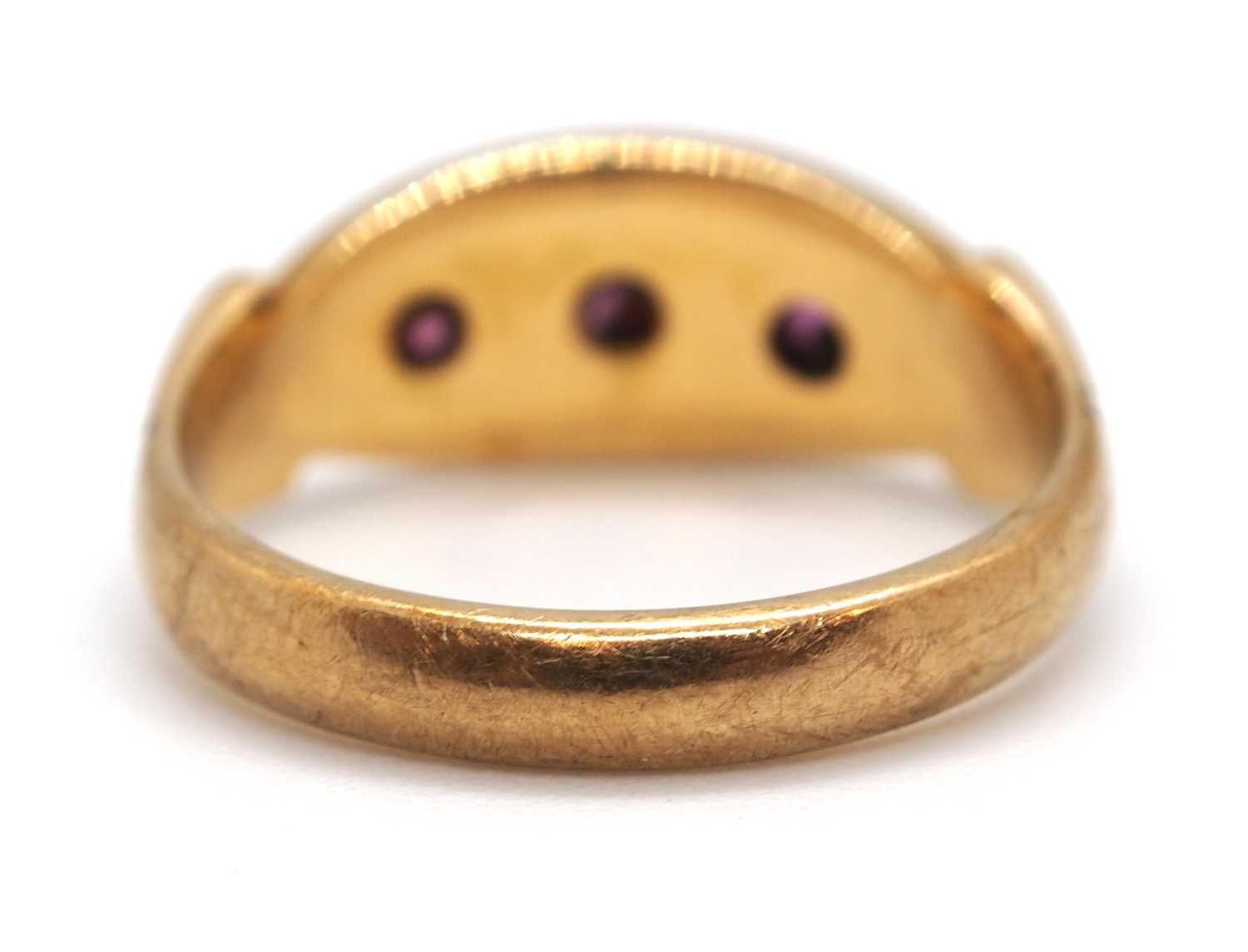 An 9ct ruby ring, the three round gypsy set rubies with plain band stamped 9ct, size I-J, 2.9g - Image 7 of 7
