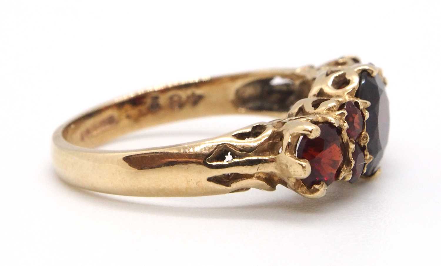 A 9ct garnet ring, the three principal graduated round garnets interspaced with small round garnets, - Image 6 of 7