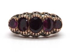 An adapted 19th century garnet ring, the five mixed cut foil backed garnets in closed back settings,