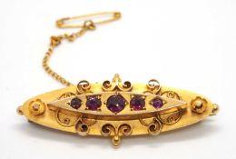 A 9ct Edwardian brooch, the navette shape brooch set with five round graudated garnets, gypsy set to
