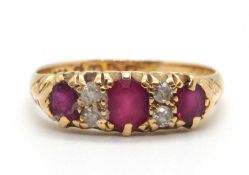 An early 20th century ruby and diamond ring, set with three graduated rubies interspaced with two