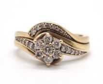 A 9ct diamond crossover ring, set with a central diamond flowerhead cluster to a two strand