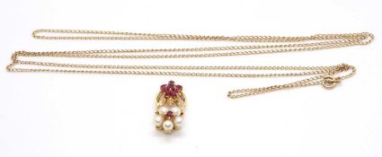 An 18ct ruby diamond and cultured pearl necklace, the pendant set with a flowerhead cluster of