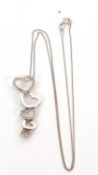 A 9K white gold diamond heart pendant and chain, the five graduated hearts with alternating hearts