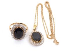 A 9ct sapphire and diamond ring and matching pendant, the dark blue-black oval sapphire surrounded