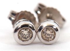 A pair of 9ct white gold diamond earstuds, the round brilliant cut diamond, total estimated