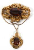 A late Victorian citrine brooch, the large central oval amber colooured citrine, collet mounted