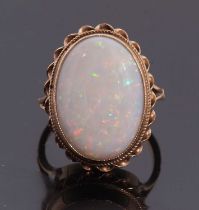 A 9ct opal ring, the oval opal cabochon, collet mounted with rope twist border, with split shoulders