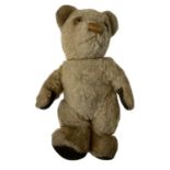 A mid 20th century teddy bear with felted paw pads, embroidered nose and gamber glass eyes. Length