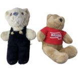 A pair of teddy bears, to include: - A vintage straw stuffed bear with furred dungarees (in need