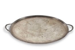 A George VI large two handle silver tray of oval form having gadrooned detail to handles and border,