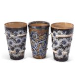 A group of three Doulton Lambeth lemonade beakers all with incised marks for George Tinworth