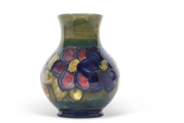 A Moorcroft vase, the baluster body with tubelined decoration with the anemone pattern on a green
