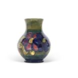 A Moorcroft vase, the baluster body with tubelined decoration with the anemone pattern on a green