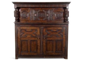 A large 17th Century oak court cupboard with moulded cornice over a top section with two panelled