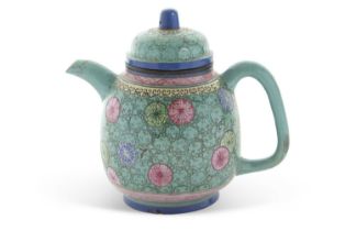 A Qing Dynasty pottery teapot with a famille vert glaze decorated with flower heads in famille