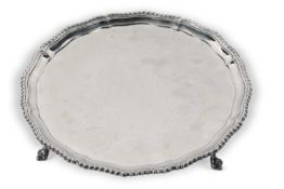 An Elizabeth II silver salver of shaped circular form with a plain ground with an applied