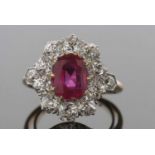 A ruby and diamond cluster ring, the oval claw mounted ruby, approx. 8.8 x 6.8 x 4.0mm, surrounded