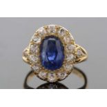 A sapphire and diamond ring, the oval mixed cut sapphire, surrounded by old mine cut diamonds, all