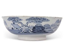 An English Delft punch bowl circa 1760 with blue and white design of house and trees in Chinese