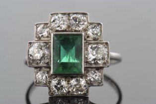 An early/mid 20th century emerald and diamond ring, the central collet mounted step cut emearld,