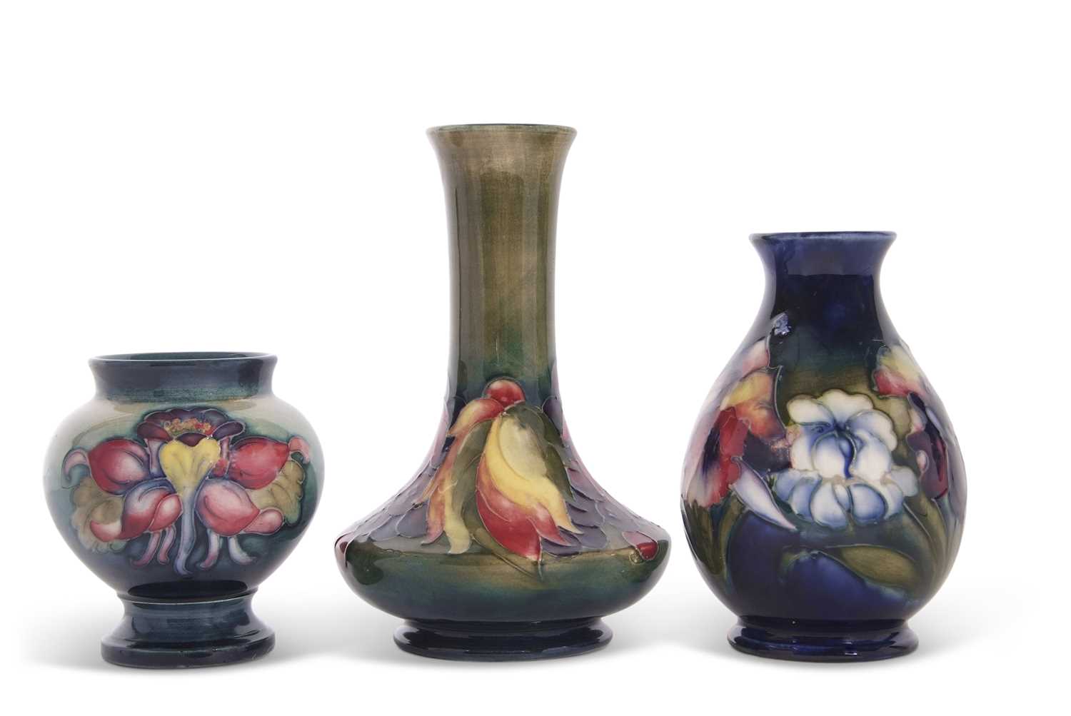 A group of three small Moorcroft vases, one with a two blind leaf and berry design on green ground