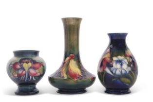 A group of three small Moorcroft vases, one with a two blind leaf and berry design on green ground